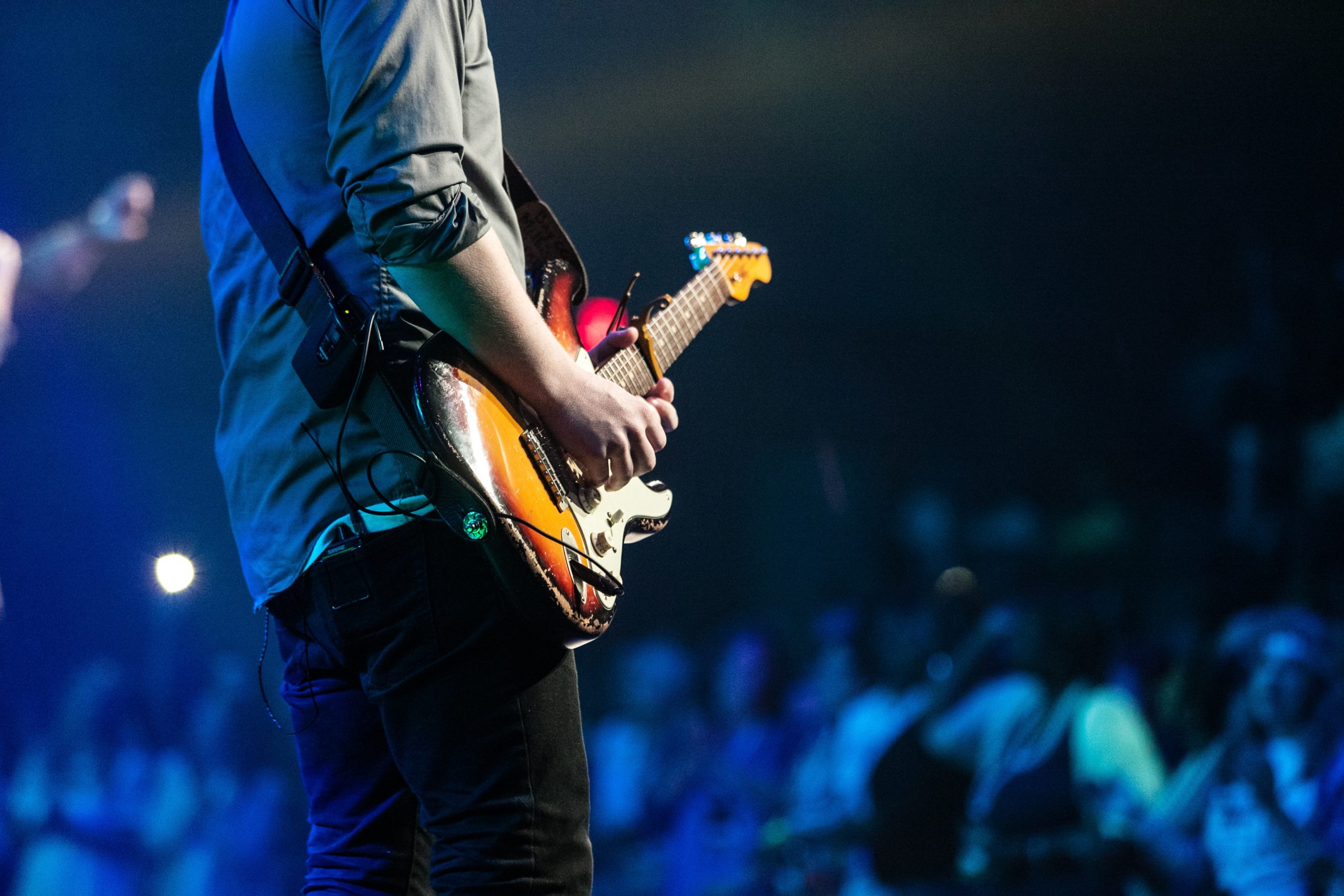 man holding a guitar performing at a concert